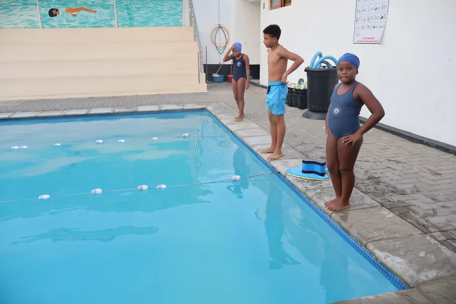 Crianças junto à piscina durante uma atividade aquática
